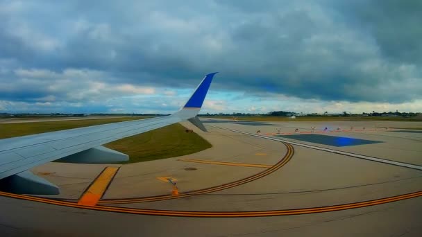 Avião está voando no céu azul através das nuvens brancas. Vista da asa do avião da janela . — Vídeo de Stock