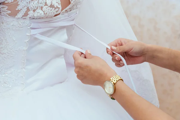 Morning bride. Bridesmaid helping the  lacing up her dress — Stock Photo, Image