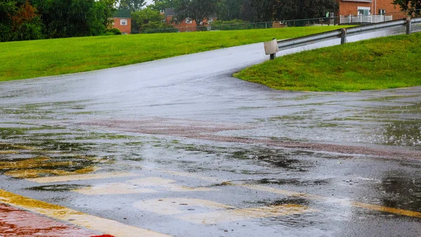 Agua de lluvia de carretera cae fondo con el reflejo del cielo azul y círculos en asfalto oscuro. previsión . — Foto de Stock