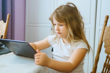 Eğitim teknolojisi ve internet kavramı - küçük öğrenci kız evde tablet pc ile