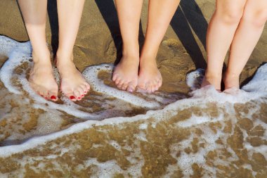 Kum okyanusu yakınlarındaki düzgün kadın bacakları