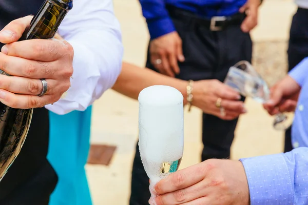 Närbild händerna på bruden och brudgummen med glas champagne — Stockfoto