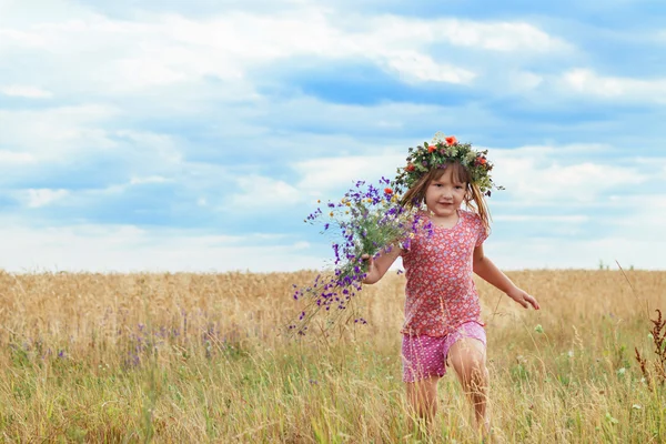 Linda menina com uma grinalda no campo de trigo — Fotografia de Stock