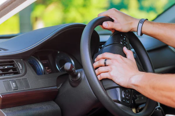 Main d'homme sur le volant d'une voiture — Photo