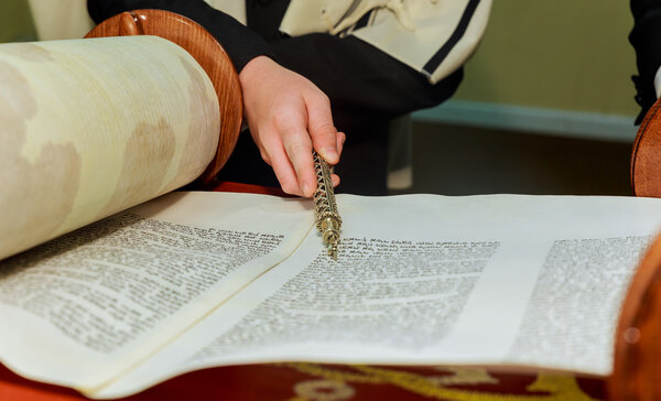 Hand of boy reading the Jewish Torah at Bar Mitzvah