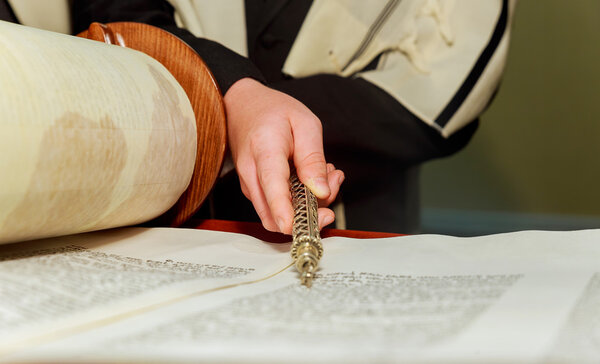 Hand of boy reading the Jewish Torah at Bar Mitzvah