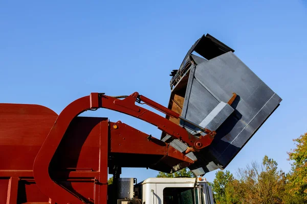 Work of public services for loading household waste from the container into the car the home maintenance