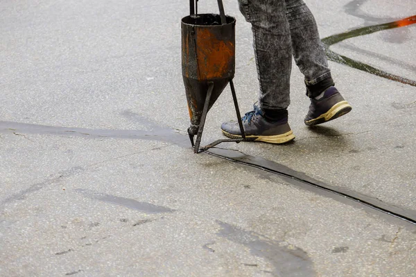İşçiler asfalta asfalt bir yol koruyucu önlük yenileme çalışması asfalt için asfalt mühür uyguluyorlar