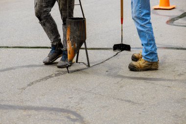 Restorasyon çalışmaları asfaltlamak için sıvı mühür takıyor. Yol kapama çatlaklarında yol koruyucu bir palto.