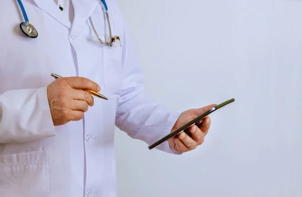 Clinic emergency hospital doctor at work physician using digital tablet while standing near desk