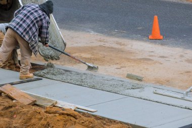 Yeni beton bir evin önünde çalışan adamlar.