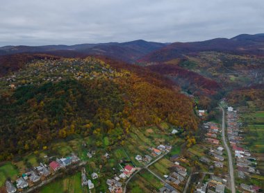 Karpaty 'nin kırsal kesiminde, yüksek dağlık yükseklikteki köye yakın, alçak hava manzaralı bir tepede.