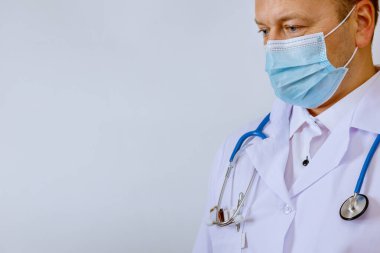 Beyaz önlüklü doktor, elinde fonendoskop var..