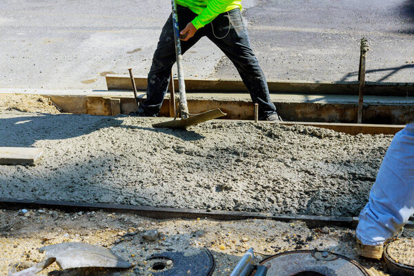 Укладка нового тротуара в мокрый бетон на свежезалитых бетонных тротуарах