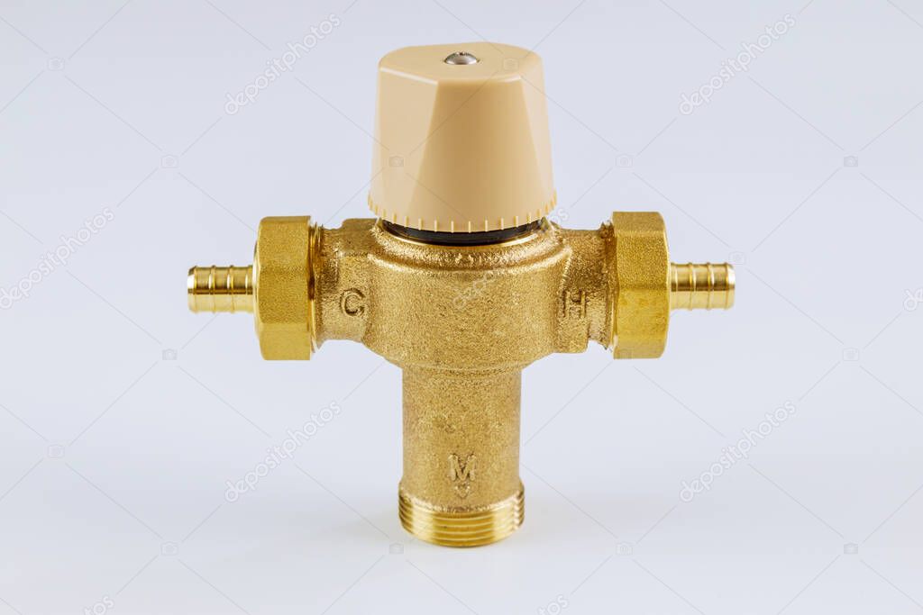 Water various supply plumbing brass thermostatic mixing valve on isolated white background.