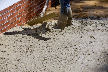 İskan kaldırımlarına çimento döken işçiler beton karıştırıcı
