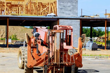 Yeni konut inşaatı için ahşap bina iskeleti yeni evdeki bir kamyon forkliftini çerçeveletiyor.