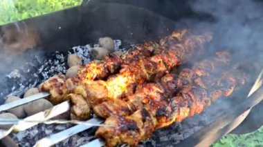Metal şişler üzerinde leziz ızgara etler kömürle kızartılıyor..