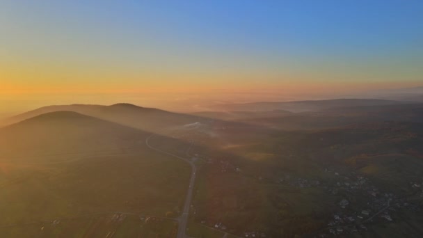 山の上からの夕景風景とオレンジの雲を通して輝く美しい劇的な太陽 — ストック動画