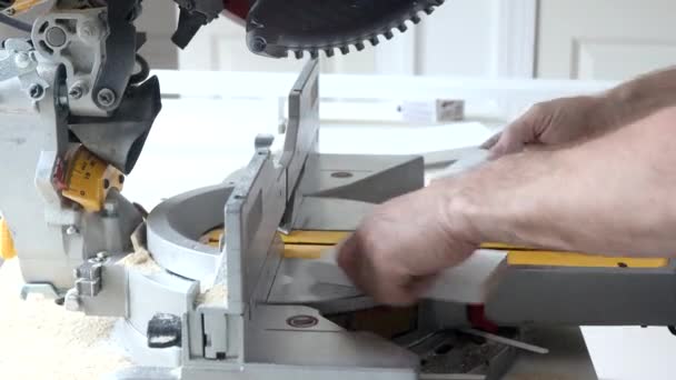 Ouvrier coupe la plinthe en bois sur la scie à onglets — Video