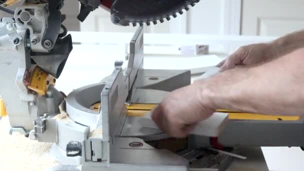 Worker cuts wood baseboard on the power miter saw — Stock Footage Worker cuts wood baseboard on the power miter saw Stock Video