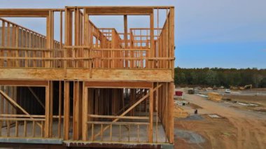 Açık mavi gökyüzünün altında güneş ışığıyla yeni inşaat kirişlerine bakıyorum.