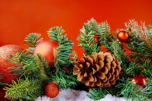 雪地上的云杉树枝上挂着圣诞装饰球 有红色的复制空间 — 图库照片