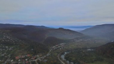Karpaty 'nin kırsal kesimindeki dağ yüksek irtifa manzaralı banliyö köyü üzerindeki havadan alçak görüntü