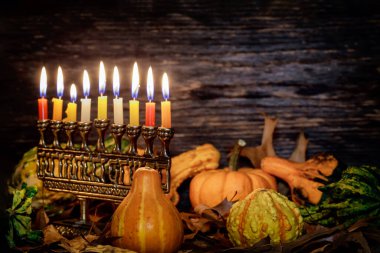 Kwanzaa holiday with decorate candles and pumpkin on wooden desk background clipart