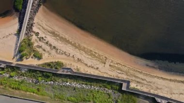 Sarı kumlu sahil, mavi deniz manzaralı dalgalar yüksekten çekiliyor.