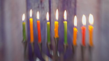 Hanukkiah 'taki sekiz mum Yahudi bayramının yedinci gününde yanıyor. Işıklar bulanık ve bulanık.
