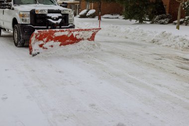 Traktör, kışın yoğun kar yağışı sonrasında kar kaldıran aracı temizler.