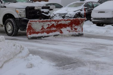 Traktör, kışın yoğun kar yağışı sonrasında kar kaldıran aracı temizler.