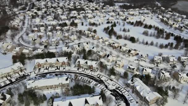 Vue aérienne sur les maisons privées en hiver de banlieues habitées traditionnelles couvertes de neige — Video