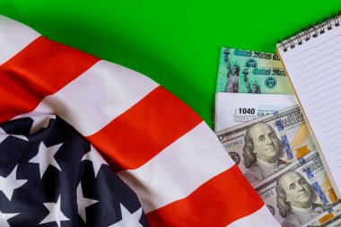 100 dolarlık banknotlarla vergi iadesi çeki. Amerikan para birimi ve spiral not defteri.