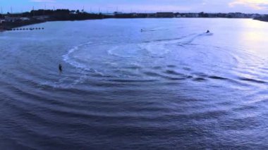 Gök mavisi sularda yüzen bir teknenin insansız hava görüntüsü.