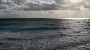Turkuaz okyanus suyunun güzel plajından Cancun silueti