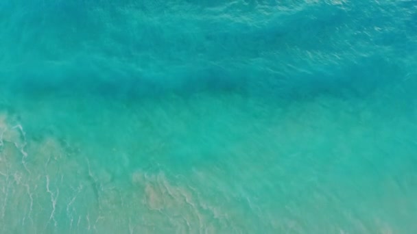 Dalgaların hava manzarasında turkuaz okyanus suyundan oluşan bir kumsal manzarası. — Stok video