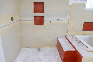 Duvarları ve zemini olan banyo yapım aşamasındaki apartmanda fayans duşu için hazır.