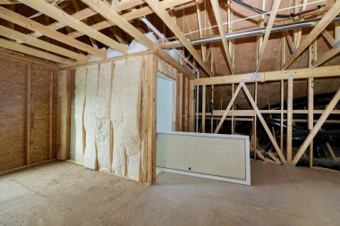 Tahta kirişler tavan arasını mineral yünü ve boru ısıtma sistemiyle yalıtıyor.