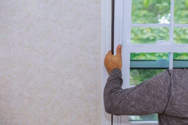 Tamir edilen işçinin elleri, tadilat sırasında plastik pencerenin yerini aldı