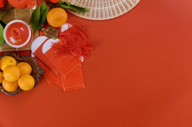 Aksesuarların en üst görüntüsü Asya Yeni Yıl Festivali dekorasyonları seremoni çay seti, Mandarin portakalları kırmızı zarf paket Ang Pau bu sezon için bir kırmızı zemin kutsaması