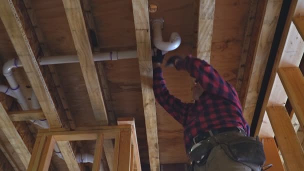 Tuyau blanc de colle de plombier, un nouveau drain en plastique de montage sous une construction — Video