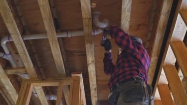 Tesisatçı elleri yapıştırıcı ile iki parça plastik drenaj borusu, yeni banyoyu kapat.