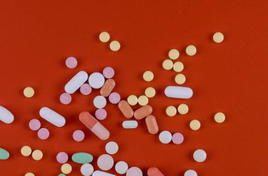 Kırmızı, sarı, beyaz renkli kırmızı kapsüller.