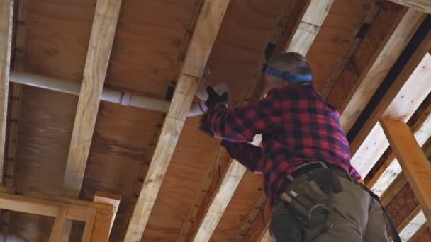 Travailleur utilisant de la colle avec raccord pour installer le tuyau de vidange en PVC dans la zone de travail. — Video