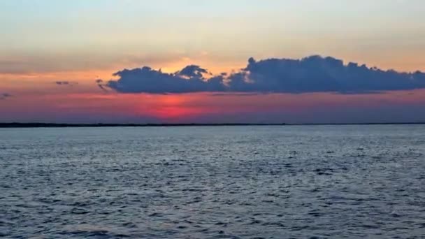 Prachtige zonsondergang boven kleurrijke oceaan met reflectie in water, majestueuze wolken aan de hemel — Stockvideo