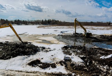 İnşaat alanındaki toprak çalışmaları sırasında inşaat kazıcıları için kazı çukurunu kazın