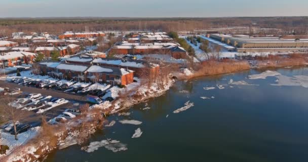 Isdrift på floden tidigt på våren av is flyter nedför strömmen utsikt lägenhetskomplex från en höjd av en av stadens bostäder — Stockvideo