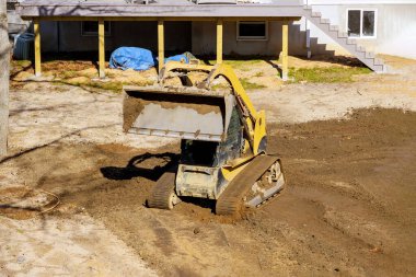 Buldozer toprak kazıcı inşaat ekipmanlarını taşıyor.